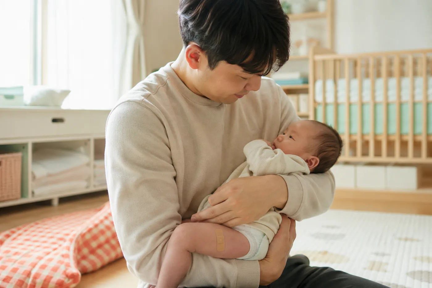 예방접종 후 아기를 안고 반응과 호흡을 살피는 아빠